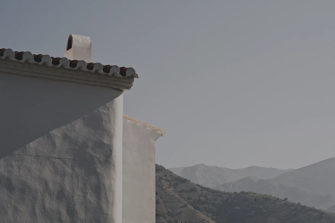 Imagen del tejado de una casa de campo y vistas a las sierras cercanas a la casa